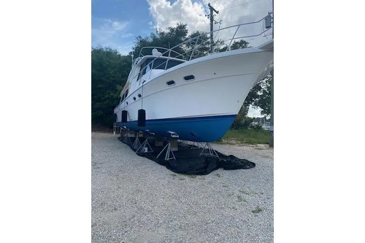 Epic Yacht Photos Pics 1998 Bayliner 4788 Pilot House Motoryacht on stands, white hull, blue bottom, outdoor setting.