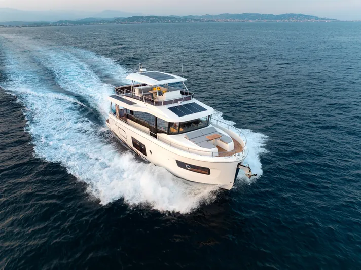 In Stock Yacht Photos Pics 2026 Beneteau Swift Trawler 54 cruising on open sea, showcasing sleek design and performance.