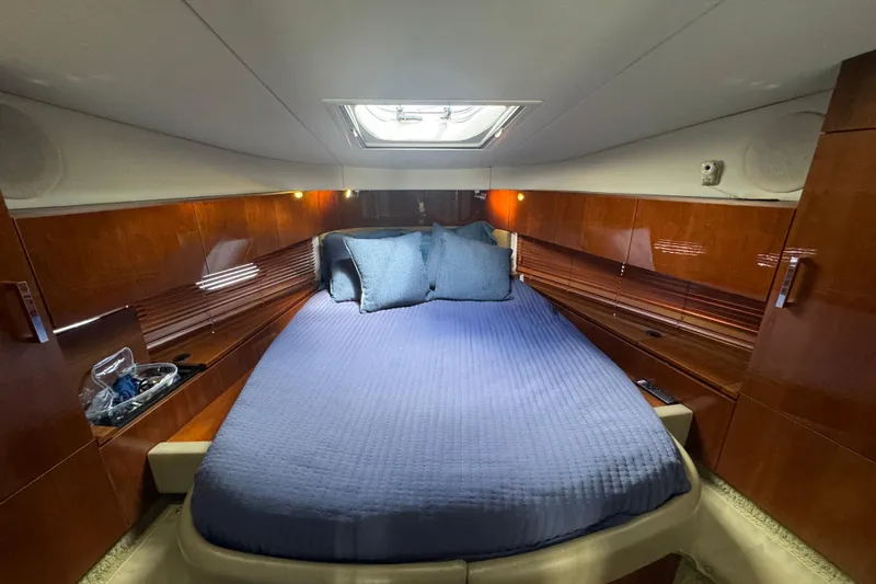 The Office Yacht Photos Pics Luxurious cabin interior of 2011 Sea Ray 470 Sundancer with blue bedding and wood paneling.