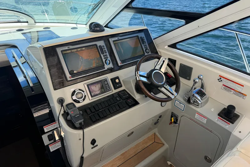 The Office Yacht Photos Pics 2011 Sea Ray 470 Sundancer helm with navigation screens and steering wheel.