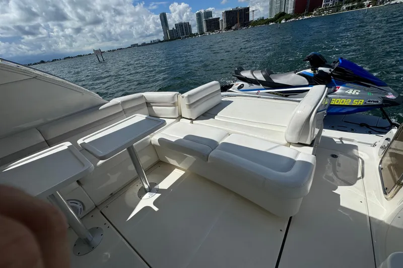 The Office Yacht Photos Pics Luxurious 2011 Sea Ray 470 Sundancer yacht with white seating and jet ski on deck.