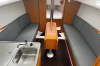 Interior of 2022 Dufour 32 yacht with modern seating and compact kitchen area.