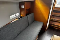 Interior of 2022 Dufour 32 yacht with gray seating and wooden accents.