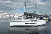 2022 Dufour 32 sailboat docked in a marina, surrounded by other boats.