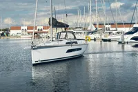 2022 Dufour 32 sailboat docked in a marina, surrounded by other boats.