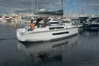 2022 Dufour 32 sailboat in marina, calm waters, overcast sky.
