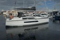 2022 Dufour 32 sailboat docked in a marina under cloudy skies.