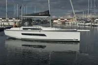 2022 Dufour 32 sailboat docked in a marina, under a cloudy sky.