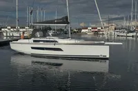 2022 Dufour 32 sailboat docked in a marina under cloudy skies.