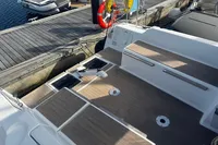 Cockpit of 2022 Dufour 32 sailboat with wooden deck and dockside view.