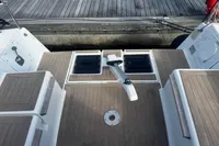 2022 Dufour 32 yacht deck with wooden finish and storage compartments.