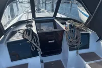 Cockpit of 2022 Dufour 32 sailboat with ropes and winches, docked at marina.
