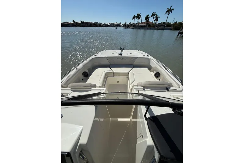  Yacht Photos Pics 2025 World Cat 260 DC-X boat interior with seating, on calm water, palm trees in background.