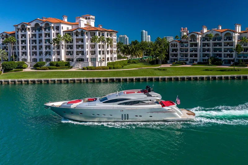 Regal Yacht Photos Pics Luxurious 2008 Pershing 90 yacht cruising near waterfront residences under clear blue skies.