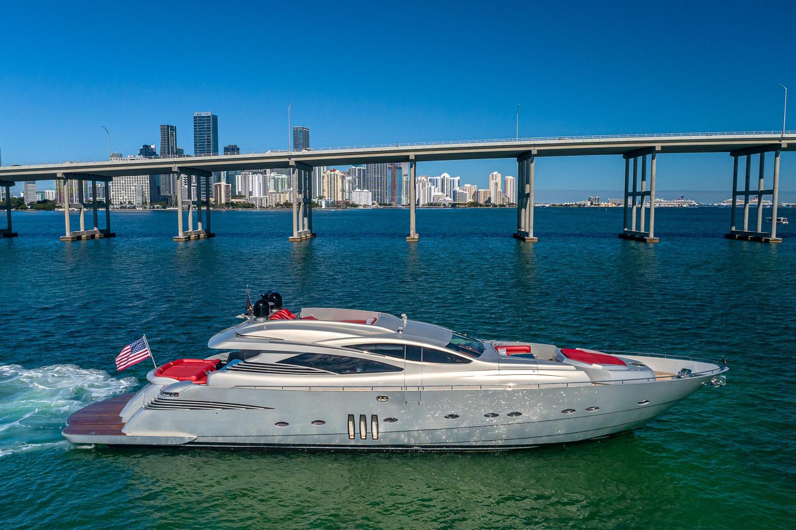 2008 Pershing 90 yacht cruising near a city skyline and bridge on a sunny day.