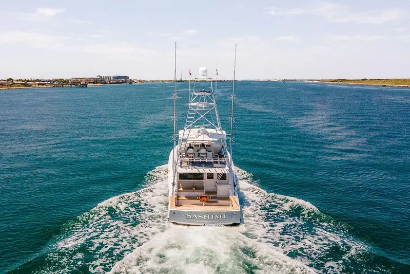 Sashimi Yacht Photos Pics 2014 Hatteras 63 GT yacht cruising on open water, rear view.