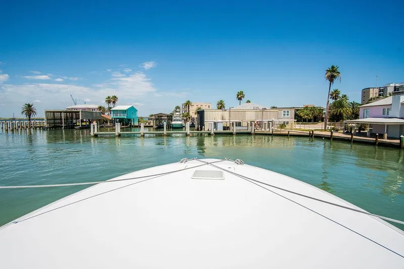 Sashimi Yacht Photos Pics Bow view of 2014 Hatteras 63 GT yacht approaching a coastal dock.
