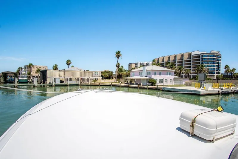 Sashimi Yacht Photos Pics Hatteras 63 GT 2014 yacht docked in sunny marina with modern buildings.