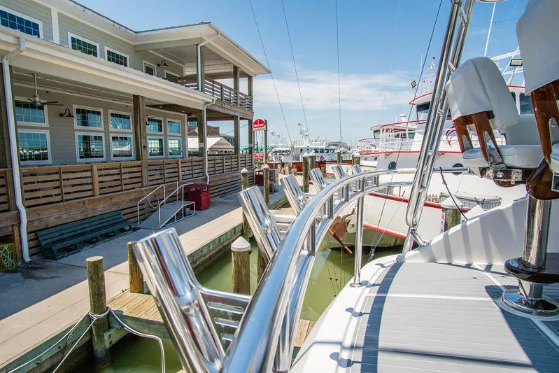 Sashimi Yacht Photos Pics 2014 Hatteras 63 GT yacht docked at marina, sunny day, waterfront building.