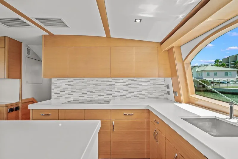 Sashimi Yacht Photos Pics Modern kitchen interior of 2014 Hatteras 63 GT yacht with sleek cabinetry and large window.