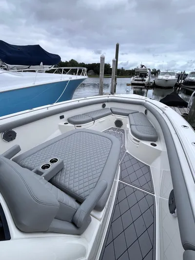  Yacht Photos Pics 2018 Boston Whaler 350 Outrage boat with sleek seating, docked at a marina.