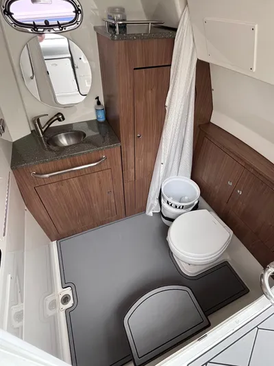  Yacht Photos Pics 2018 Boston Whaler 350 Outrage bathroom with sink, toilet, and wooden cabinetry.
