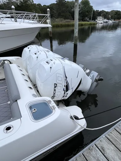  Yacht Photos Pics 2018 Boston Whaler 350 Outrage with triple outboard engines docked by the water.