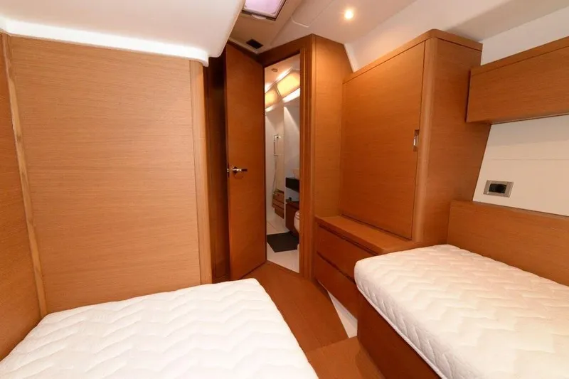  Yacht Photos Pics Interior of 2019 Grand Soleil 48 Performance yacht with twin beds and wooden cabinetry.