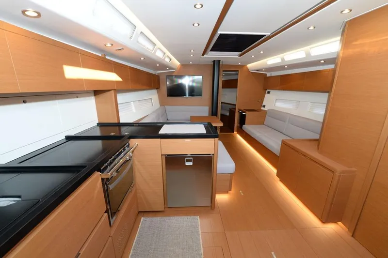  Yacht Photos Pics Luxurious interior of 2019 Grand Soleil 48 Performance yacht with modern kitchen and seating area.