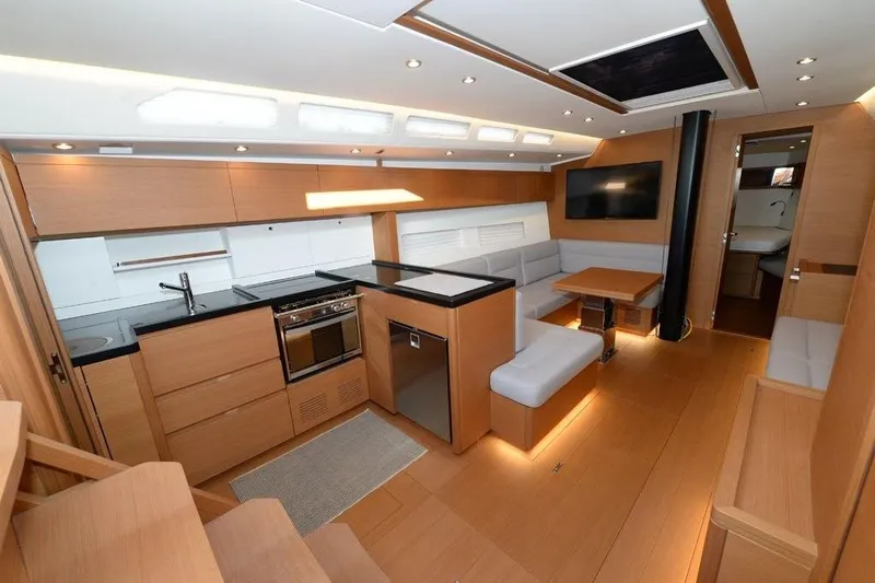  Yacht Photos Pics Luxurious interior of 2019 Grand Soleil 48 Performance yacht with modern kitchen and seating area.