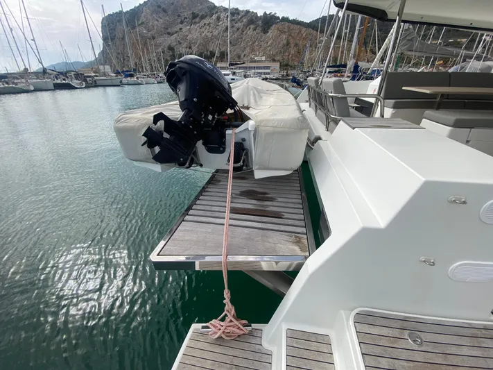 Luna Yacht Photos Pics 2020 Fountaine Pajot Saona 47 catamaran with dinghy, docked in a scenic marina.