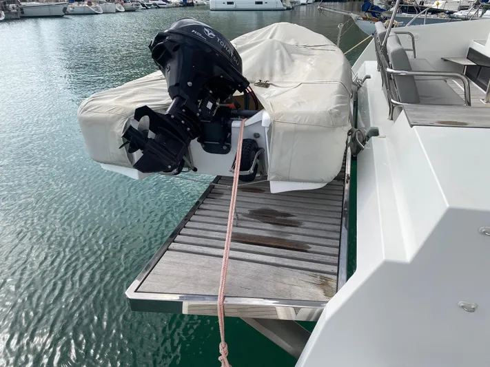 Luna Yacht Photos Pics Fountaine Pajot Saona 47 catamaran with covered outboard motor on deck, docked in marina.