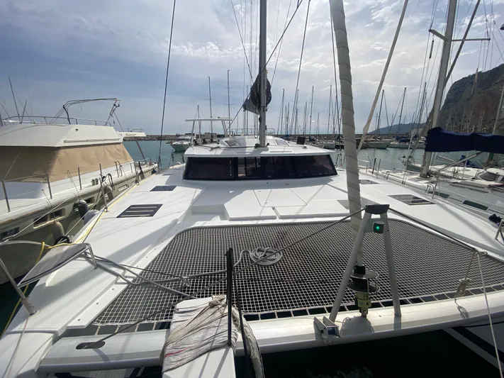 Luna Yacht Photos Pics 2020 Fountaine Pajot Saona 47 catamaran docked in a marina, showcasing its spacious deck.