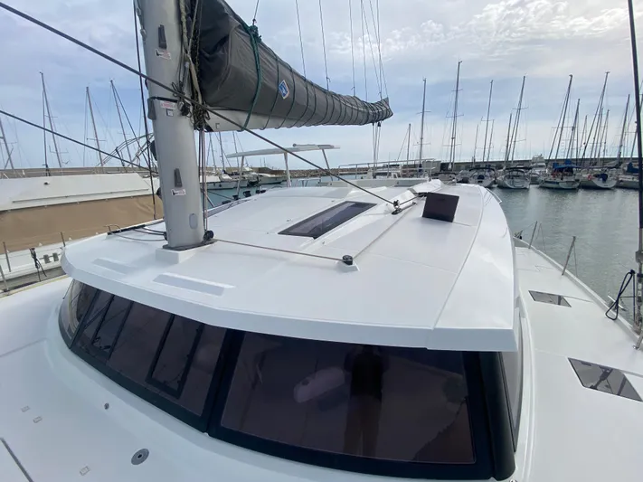 Luna Yacht Photos Pics 2020 Fountaine Pajot Saona 47 catamaran docked in a marina, showcasing sleek design and spacious deck.