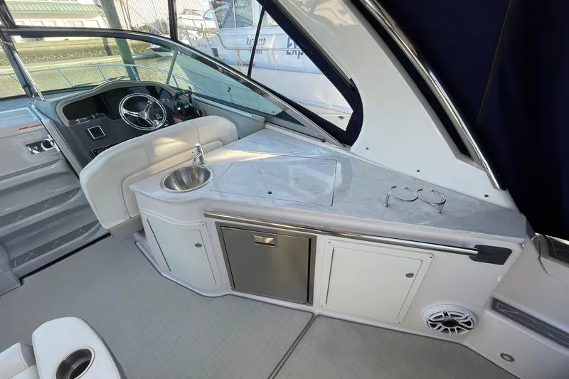 Then Again Yacht Photos Pics 2021 Regal 33 XO boat interior with helm, sink, and storage cabinets.