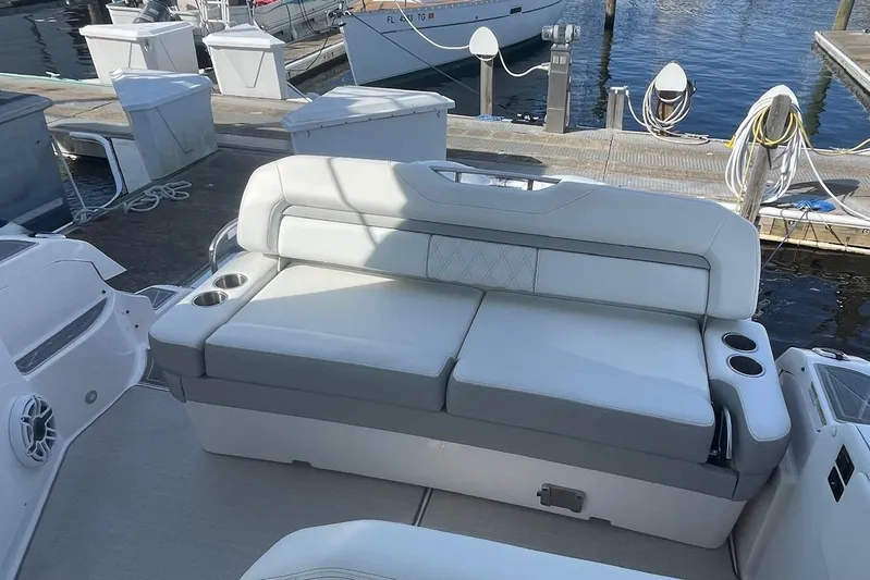 Then Again Yacht Photos Pics 2021 Regal 33 XO boat interior with white cushioned seating and cup holders at a marina.