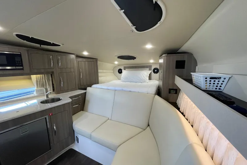Then Again Yacht Photos Pics 2021 Regal 33 XO boat interior with modern kitchen, seating, and cozy sleeping area.