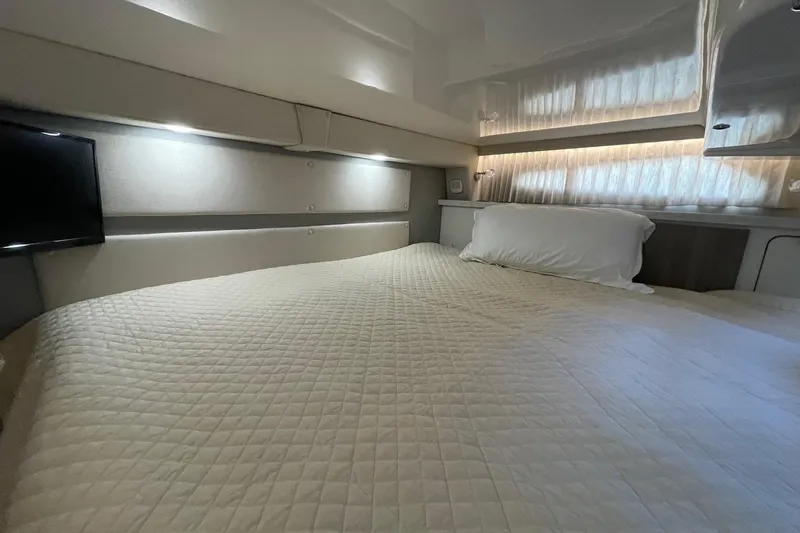 Then Again Yacht Photos Pics Luxurious cabin interior of 2021 Regal 33 XO yacht with cozy bedding and ambient lighting.
