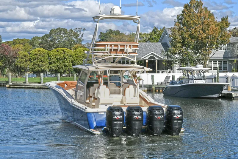  Yacht Photos Pics 2016 Scout 420 LXF boat with four engines docked near waterfront homes.