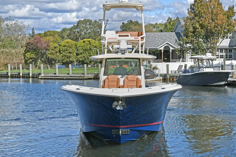  Yacht Photos Pics 2016 Scout 420 LXF boat on water, front view, with trees and houses in background.