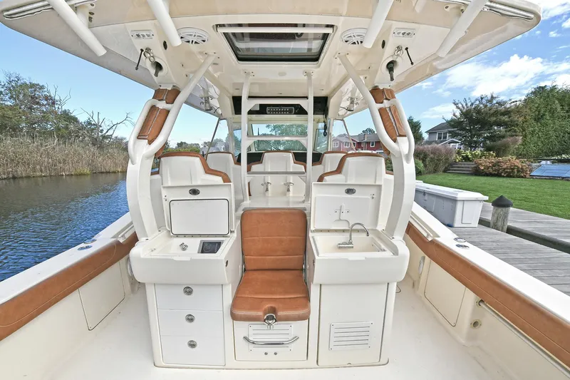  Yacht Photos Pics 2016 Scout 420 LXF boat interior with seating, storage, and sink by a dock.