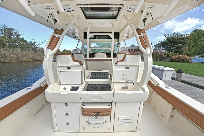  Yacht Photos Pics 2016 Scout 420 LXF boat interior with seating, storage, and sink by the water.