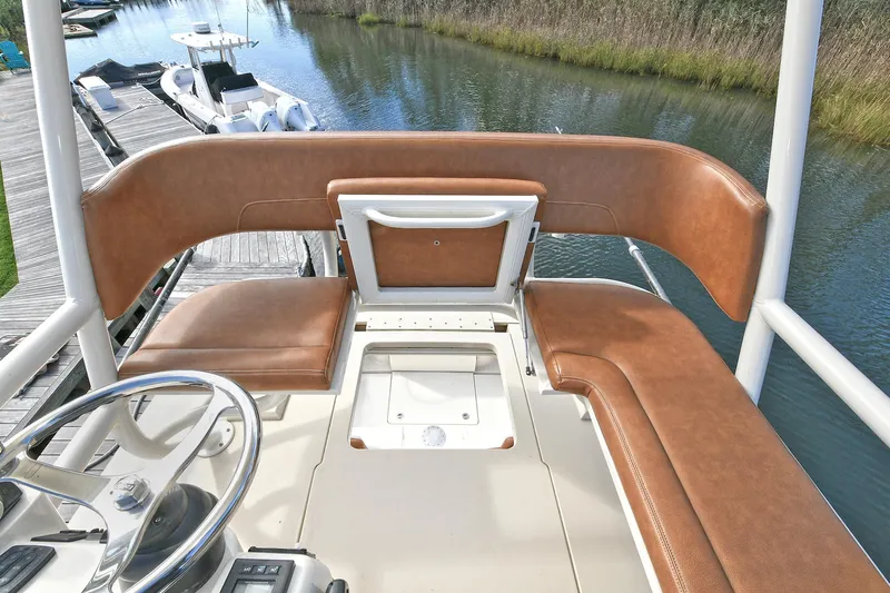  Yacht Photos Pics 2016 Scout 420 LXF boat helm with brown leather seating and steering wheel.
