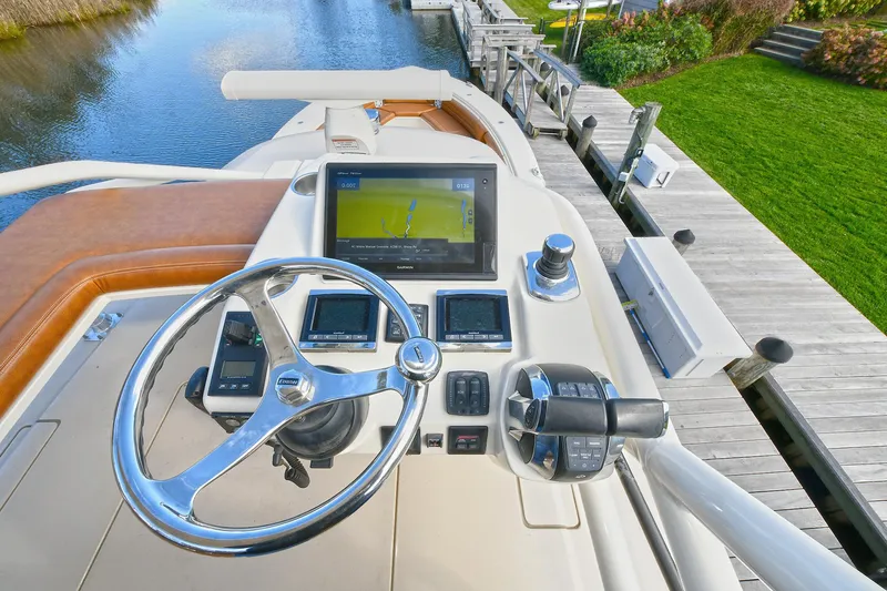  Yacht Photos Pics Helm of 2016 Scout 420 LXF boat with navigation screens and steering wheel.