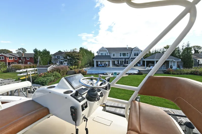  Yacht Photos Pics 2016 Scout 420 LXF boat helm with waterfront view and luxury homes in the background.