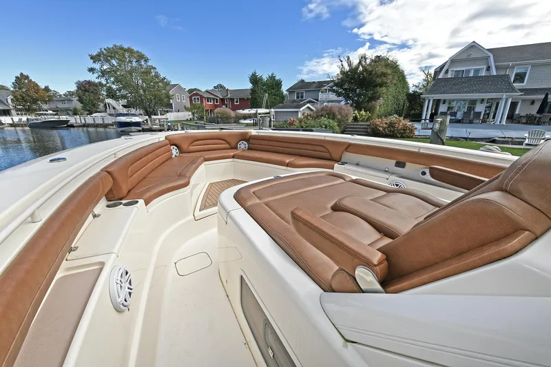  Yacht Photos Pics Luxurious 2016 Scout 420 LXF boat interior with brown leather seating, docked near waterfront homes.