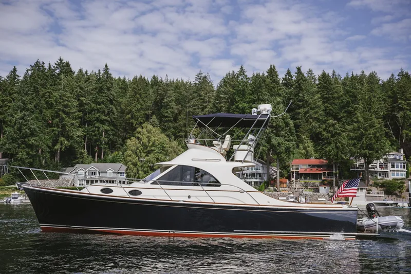 Mm Yacht Photos Pics 2010 San Juan SJ40FB IPS yacht on a serene lake with forested shoreline.