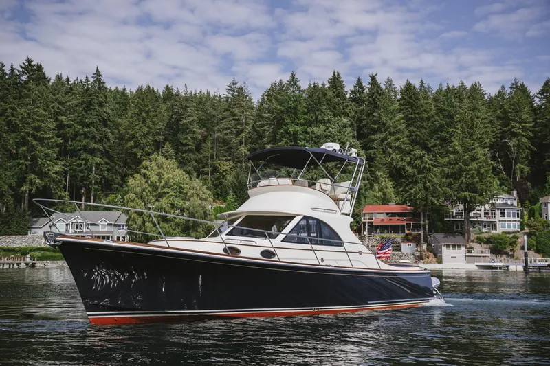 Mm Yacht Photos Pics San Juan SJ40FB IPS 2010 yacht cruising near forested shoreline and waterfront homes.