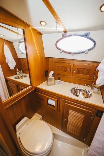 Mm Yacht Photos Pics Luxurious wooden boat bathroom with sink, mirror, and porthole window, San Juan SJ40FB IPS 2010.