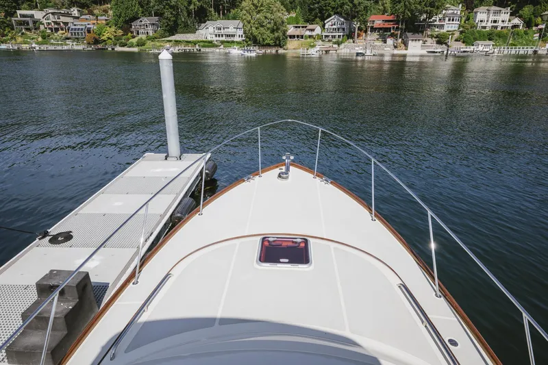 Mm Yacht Photos Pics Bow view of 2010 San Juan SJ40FB IPS yacht docked by a serene waterfront.